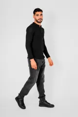 Remera de manga larga color negro, confeccionada en algodón, con cuello redondo y cierre frontal parcial con botones.