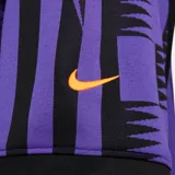 Remera deportiva Nike de la línea Culture of Football, con diseño estampado en tonos negros y violetas inspirado en el fútbol, cuello en V y mangas cortas.