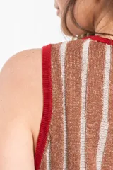 Vestido corto de punto con brillo y diseño de rayas verticales en tonos beige y marrón, sin mangas, con escote redondo y ribetes en color rojo.