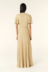 Vestido largo dorado de punto con mangas cortas con volantes, escote en V y cierre frontal con botones.