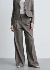 Pantalón de vestir wide leg color marrón, con tiro alto, pinzas frontales, bolsillos laterales y cierre frontal con botón, gancho y cremallera.