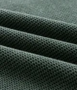 Suéter de punto color verde oscuro con textura, cuello redondo y mangas largas con diseño de corte raglán. Presenta puños y cintura acanalados, con un corte boxy moderno y estructurado.