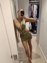 Vestido corto con estampado botánico en tonos verdes y marrones, diseño con escote profundo tipo halter, aberturas laterales en la cintura y falda ajustada con frunces.