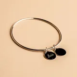 Brazalete tipo esclava de alambre redondo en plata 925, con dos medallas circulares colgantes, una de ellas con grabado personalizado.