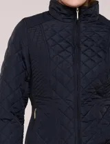 Campera capitoneada negra con costuras multidireccionales, cuello alto, cierre frontal y bolsillos laterales con cierre.