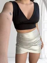 Minifalda plateada de ecocuero con diseño drapeado y corte cruzado.