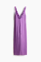 Vestido midi color lila, de corte recto, con escote en V profundo decorado con volados y tiras finas para anudar.