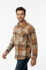 Sobrecamisa de franela a cuadros en tonos marrones, blancos y rojos, con mangas largas, bolsillos frontales con solapa y cierre de botones.