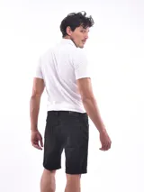 Bermuda de jean de corte slim, color azul claro lavado, con roturas y cordón ajustable en la cintura. El ruedo está doblado.