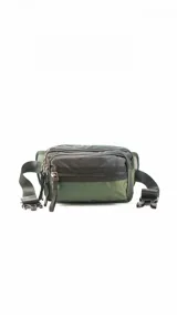 Riñonera de diseño técnico con tres compartimentos independientes con cierre. Presenta una combinación de colores en verde oliva y negro, con correa ajustable y hebilla de seguridad.