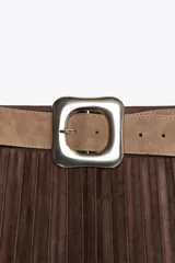 Falda midi plisada de tiro alto color marrón, con cinturón ancho de color beige y hebilla metálica cuadrada. Cierre lateral con cremallera oculta.