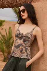 Tankini de diseño ajustado con estampado paisley en tonos grises, tostados y celestes, con escote en V y detalle de argolla de carey en el centro.