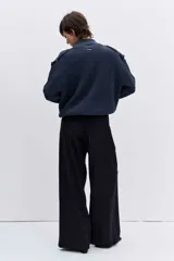 Cardigan de punto acanalado en color bordó, con cuello polo y cierre frontal de botones. Presenta un diseño de hombros caídos y mangas largas con puños ajustados.