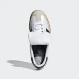 Championes Adidas Samba LT de diseño retro, confeccionados en cuero de primera calidad con puntera de nobuk. Presentan las icónicas tres bandas laterales en negro, suela de goma color caramelo y una lengüeta extragrande inspirada en las botas de fútbol clásicas.