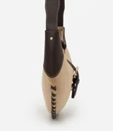 Cartera tipo baguette de diseño curvo, confeccionada en gamuza sintética color beige con detalles en cuero marrón oscuro. Presenta costuras decorativas en los bordes, una correa ajustable y cierre frontal con hebilla metálica dorada.