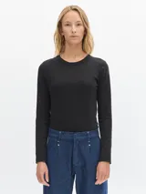 Remera negra de manga larga con cuello redondo y bordado en el frente.