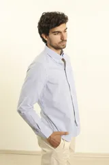 Camisa celeste a rayas verticales, de corte clásico, con cuello button-down y manga larga.