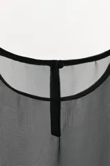 Top negro sin mangas de organza translúcida con cuello redondo, detalle de sujetador interior a contraste, y bajo acabado con aplicación de tejido de punto con diseño texturizado.