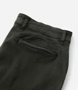Pantalón de corte slim confeccionado en sarga lavada color verde militar. Presenta cierre frontal con botón y cremallera, cintura con trabillas para cinturón y bolsillos laterales y traseros.