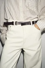 Cinturón de piel 100% color marrón oscuro, con 2,5 cm de ancho y hebillas multiposición en tono dorado.