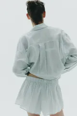 Short de algodón con estampado de rayas verticales finas en tonos verde menta y blanco. Presenta cintura elástica y corte holgado.