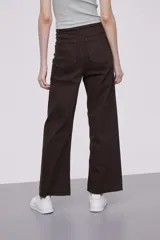 Pantalon de jean color marrón, de corte ancho y tiro alto, con terminación de ruedo desflecado.