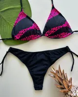 Conjunto de bikini de dos piezas con corpiño triangular con estampado animal print en tonos fucsia y negro, combinados con bandas negras, y bombacha colaless negra con tiras laterales regulables.