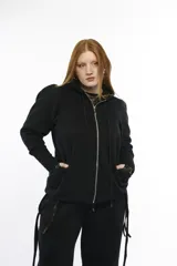 Campera deportiva oversize con capucha, cierre metálico frontal y bolsillos laterales. Presenta mangas raglán con volumen pronunciado y puños largos acanalados. Confeccionada en felpa de algodón, con cordones regulables a tono y terminaciones metálicas.