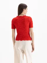 Top Charlotte de algodón y lino color negro, con calce al cuerpo, largo a la primera cadera, frunces en el exterior y escote semi alto con volado, al igual que los puños de las mangas cortas.