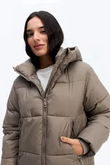 Campera puffer negra con cuello alto, cierre frontal y bolsillos laterales con cierre. Diseño acolchado de volumen medio.
