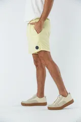 Short de baño liso con cintura elástica y cordón de ajuste. Cuenta con dos bolsillos laterales, un bolsillo posterior y un aplique de logo en goma en la pierna.