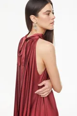 Vestido largo de viscosa color bordó, con cuello halter alto, corte holgado y volante fruncido en el bajo.