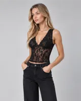 Top de encaje negro con escote en V pronunciado y tirantes anchos, confeccionado con un diseño translúcido.