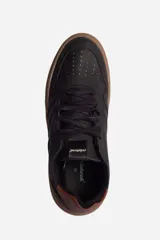 Zapatillas urbanas negras con suela marrón.