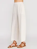 Pantalón palazzo de tiro alto color beige, confeccionado en mezcla de lino y viscosa, con silueta suelta y fluida, cintura elastizada, bolsillos delanteros aplicados y ruedo festoneado de corte tobillero.