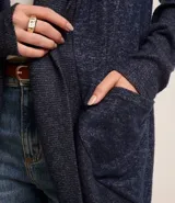 Cardigan alargado de punto color gris, con abertura frontal y bolsillos laterales.