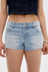 Short de jean tiro bajo y calce ajustado, con dobladillos deshilachados.