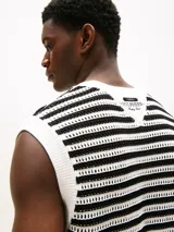 Chaleco de punto calado a rayas horizontales blancas y negras, con cuello redondo y logo de la marca bordado en el pecho.