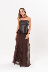 Pollera larga color chocolate confeccionada en microtul, totalmente forrada, con diseño fluido y volados en cascada que aportan movimiento.