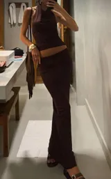 Conjunto de dos piezas color marrón oscuro, compuesto por un top halter con cuello drapeado y una falda larga ajustada.