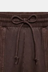 Pantalón cargo de tiro medio con efecto lavado, confeccionado en algodón. Presenta cintura elástica ajustable con cordones, bolsillos laterales y bolsillos de plastrón con solapa en las piernas. Diseño de pierna recta con combinación de tejidos a tono.