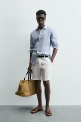 Camisa de hombre de manga larga, cuello italiano y corte regular fit, confeccionada en tejido de lino a rayas verticales azules y blancas.