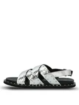 Sandalias planas de cuero plateado con textura efecto piel de serpiente y tachas metálicas aplicadas en las tiras cruzadas y en el borde de la suela. Cuentan con tira trasera con hebilla de ajuste.