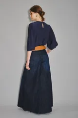 Pantalón de jean de tiro alto y pierna ultra ancha, confeccionado en denim confort con elastano y lavado azul oscuro. Presenta bolsillos traseros con bordado de alas y forrería estampada con el logo de la marca.