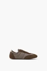 Zapatilla combinada en tonos verde oliva y marrón, con paneles acolchados y detalles en gamuza.
