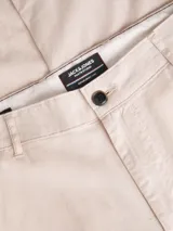 Pantalón chino de corte regular y tiro medio, con cierre de cremallera, bolsillos laterales y traseros. Confeccionado en tejido twill con mezcla de algodón y lino.