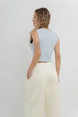 Pantalón 3/4 estilo palazzo confeccionado en denim liviano de tono amarillo pastel, tiro medio con pliegues delanteros, bolsillos delanteros y traseros aplicados, con detalle de logo metálico PEACH en la parte posterior.