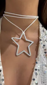 Gargantilla tipo choker compuesta por una tira doble de cuero sintético blanco y un dije metálico plateado en forma de estrella calada.