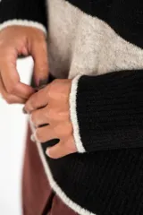 Sweater de punto con rayas horizontales en tonos azul, marrón y beige, de corte holgado y manga larga.