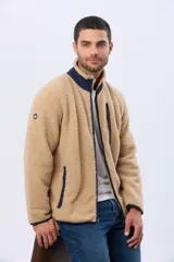 Campera de corderito con interior de polar, cuello alto y cierre frontal. Presenta un bolsillo vertical con cierre en el pecho, bolsillos laterales y detalles de ribete en contraste.